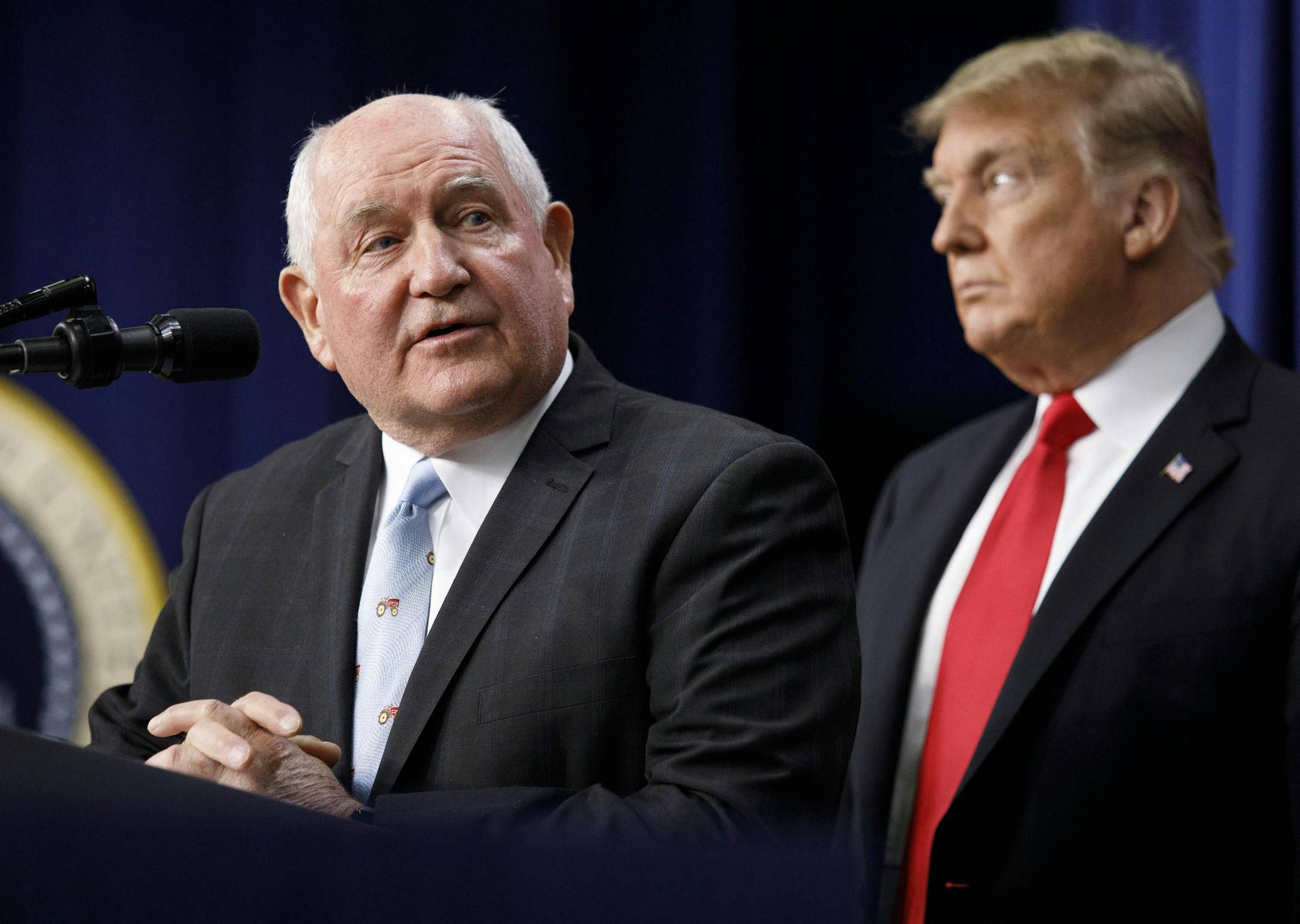 Agriculture Secretary Sonny Perdue and President Donald Trump at the signing ceremony for the $867 billion farm bill in Washington, Dec. 20, 2018. The Trump administration announced that it would seek to&#xa0;put in place&#xa0;more stringent work requirements for adults who rely on food stamps, even as the president signed the farm bill in which lawmakers had rejected stricter rules. (Tom Brenner/The New York Times)