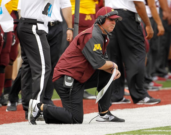 Minnesota coach Jerry Kill kneels on the sidelines during a game against Western Illinois.
