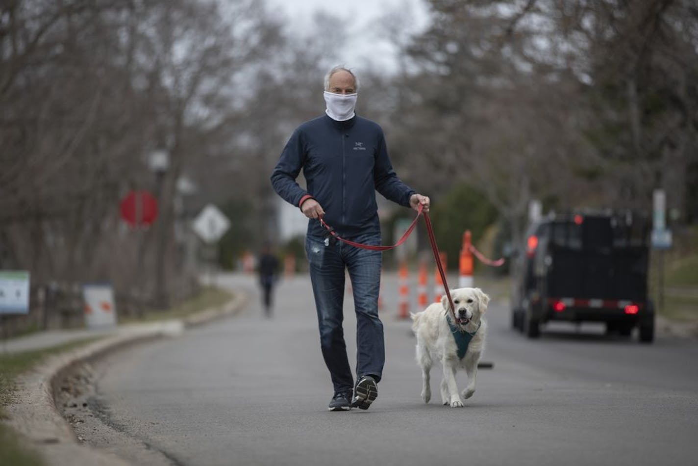 Peter Welles walked his dog Loonie on Bde Maka Ska Parkway near 36th Street along the lake .Traffic cones are placed along the parkway making traffic flow just one way.