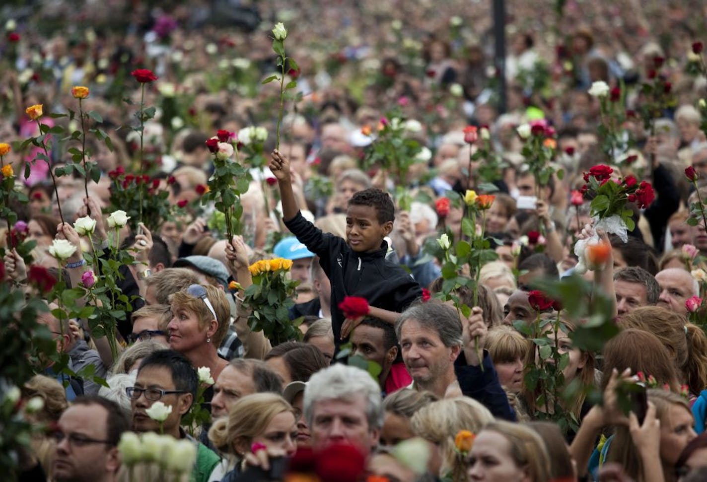 People gathered outside Oslo City Hall on July 25, 2011, to participate in a "rose march" in memory of the victims of a deadly bomb attack and shooting massacre in Norway that had occurred a few days earlier.