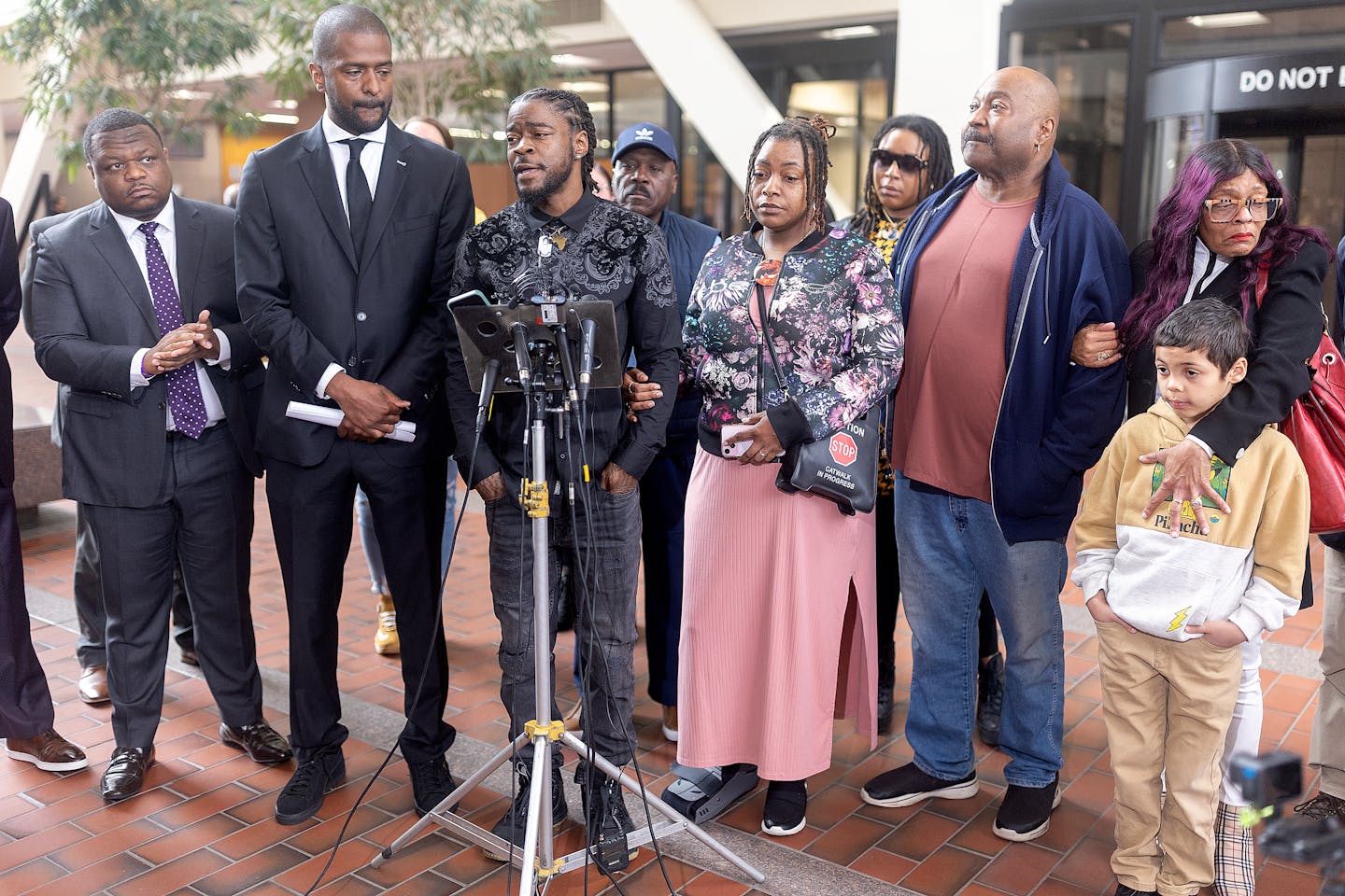 Surrounded by lawyers and family, Ricky Cobb’s twin brother Rashad Cobb, center, addresses the media about the lawsuit the family is filing against 