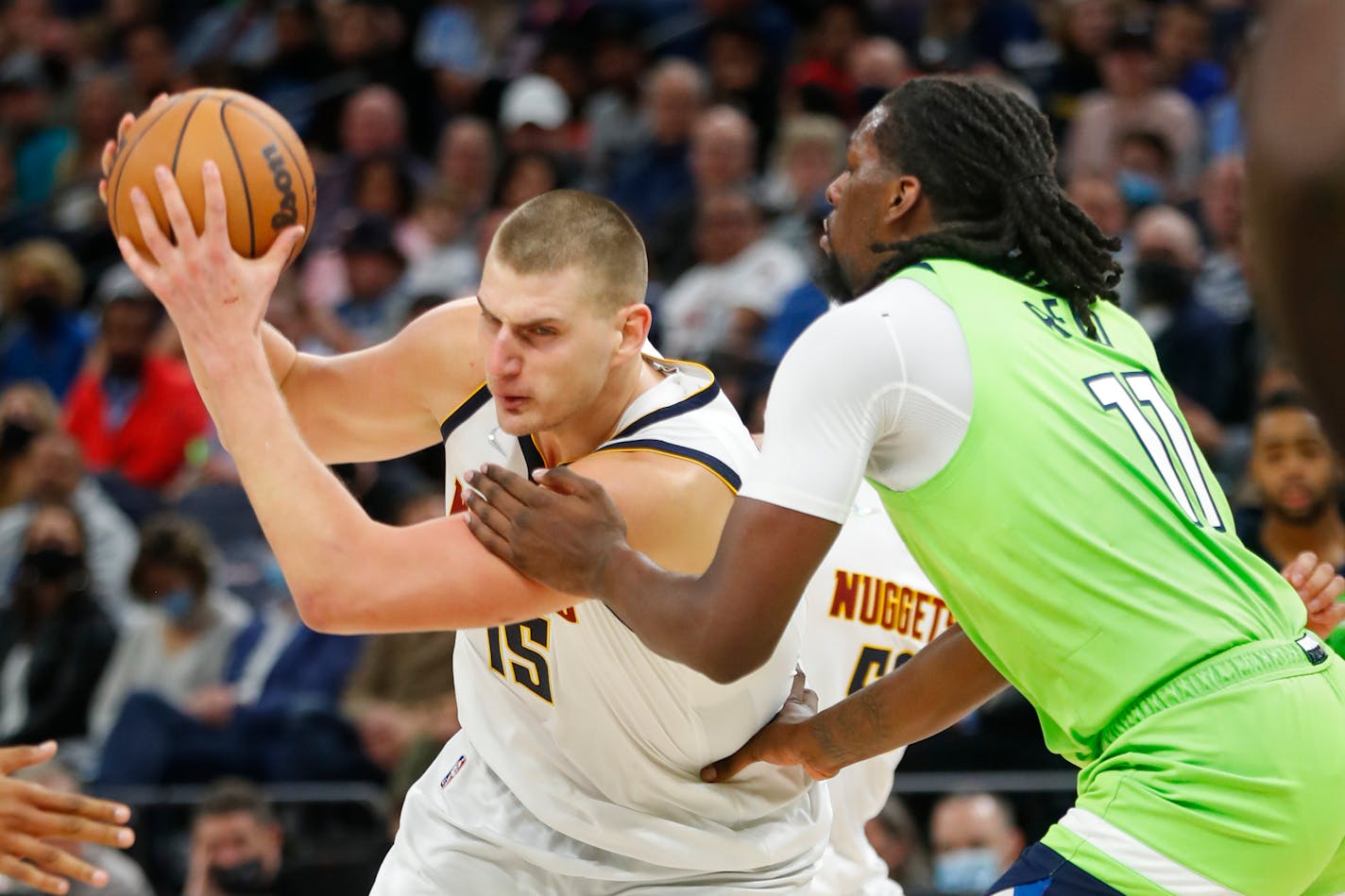 Denver Nuggets center Nikola Jokic (15) drives around Minnesota Timberwolves center Naz Reid (11) in the fourth quarter of a NBA basketball game Saturday, Oct. 30, 2021, in Minneapolis. The Nuggets won 93-91. (AP Photo/Bruce Kluckhohn)