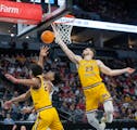 Gophers guard Cam Christie, left, and forward Parker Fox (23) defend Michigan State's A.J. Hoggard during the Big Ten tournament at Target Center. The