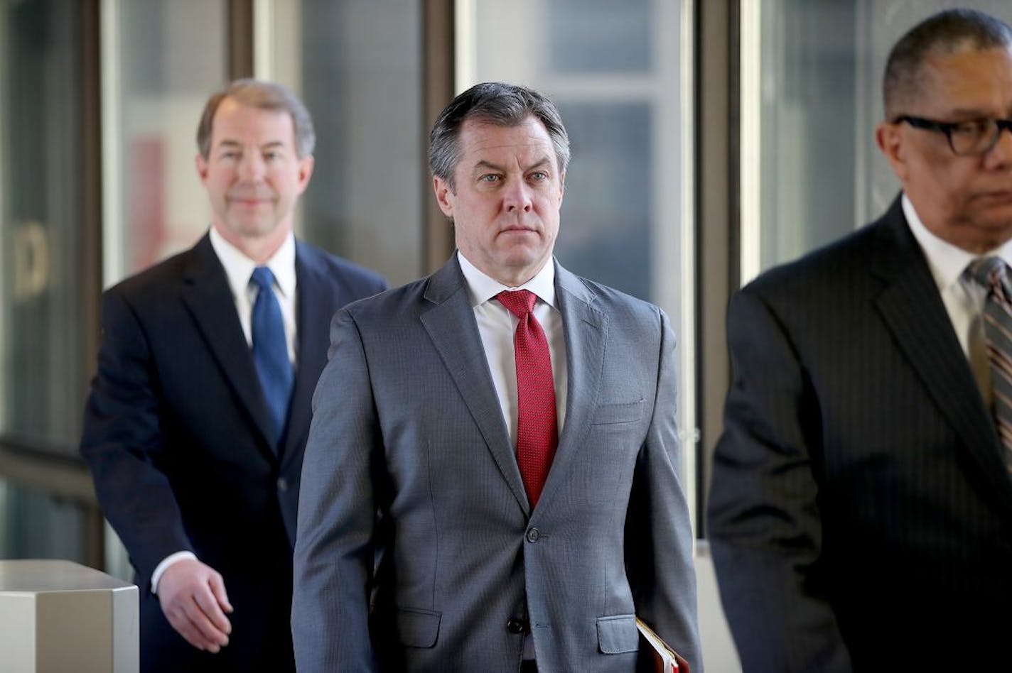 Assistant Ramsey County Attorney Rick Dusterhoft, center, made his way out of the courthouse in St. Paul after a hearing Wednesday about whether charges against Officer Jeronimo Yanez in the fatal shooting of Philando Castile should be dismissed.