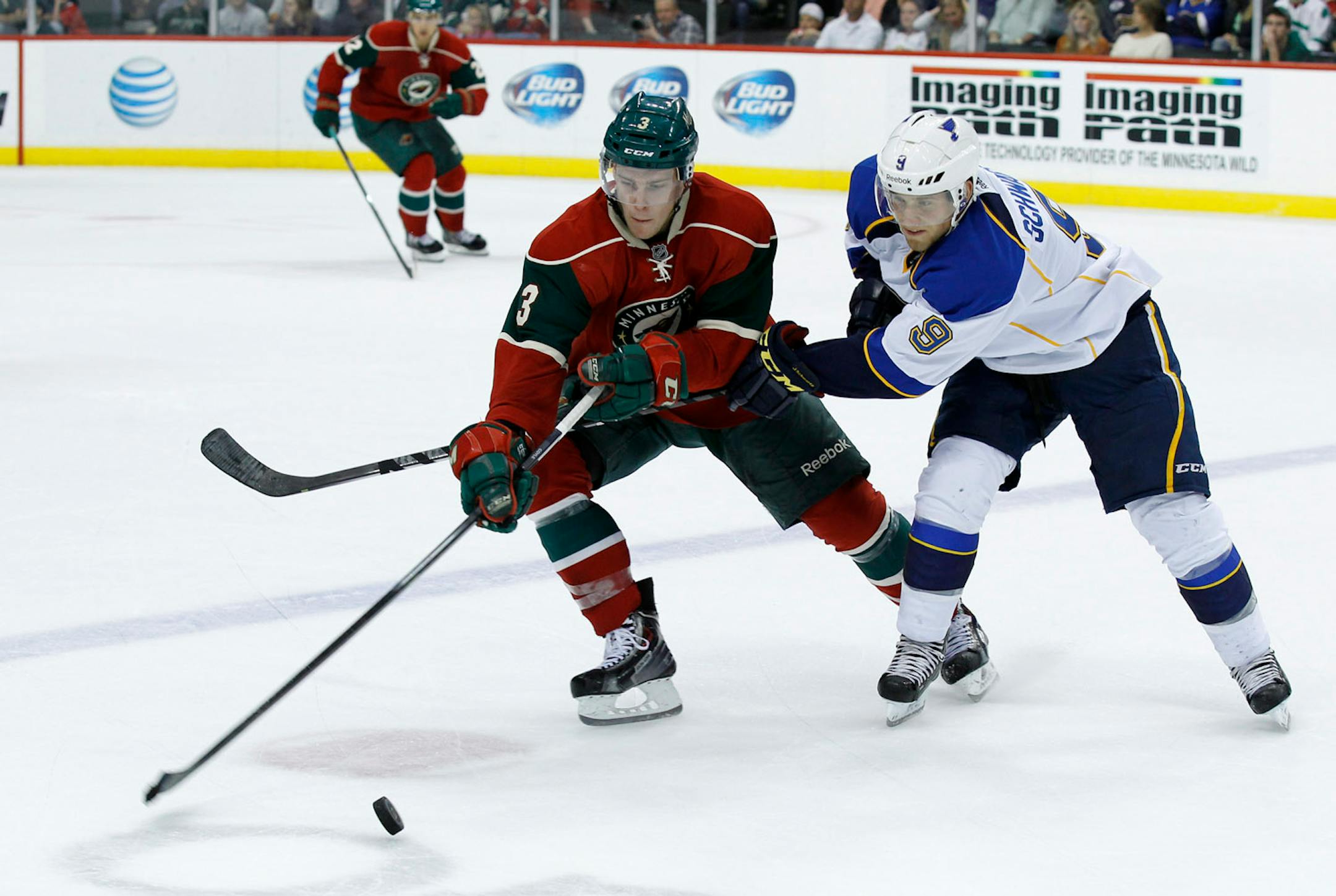 Minnesota Wild center Charlie Coyle (3) and St. Louis Blues center Jaden Schwartz (9) chase the puck during the second period of a preseason NHL hockey game in St. Paul, Minn., Wednesday, Sept. 25, 2013. (AP Photo/Ann Heisenfelt)