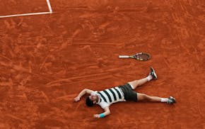Carlos Alcaraz celebrates after winning the marathon men's final of the French Open over Jannik Sinner on Sunday in Paris.