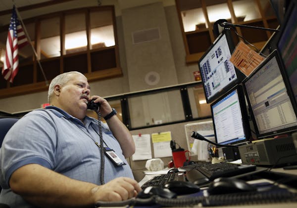 Gregers M. Nelson, senior shift supervisor at the Minneapolis Emergency Communications Center in City Hall, talked by phone to emergency personnel.
