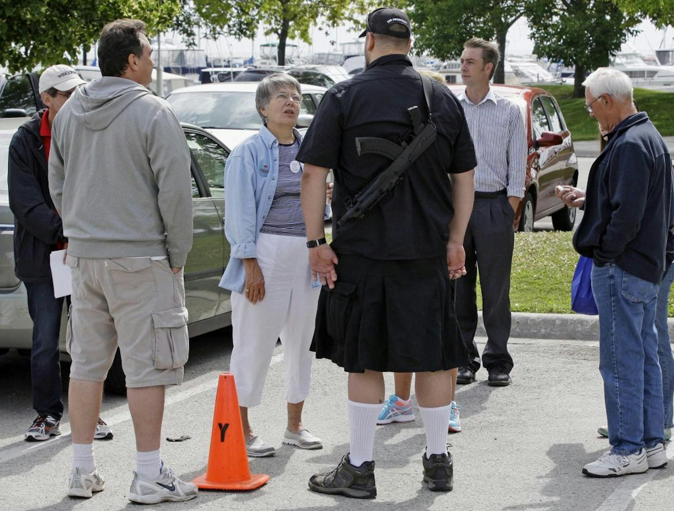 In this July 25, 2014 photo, a man open carries an AK-47 strapped to his back to make a point that it's legal to openly carry a licensed firearm in Wisconsin before Tonette Walker's visit to Sheboygan, Wis. Walker visited Sheboygan as part of her Walk with Walker campaign to showcase the state's scenic areas. (AP Photo/The Sheboygan Press, Gary C. Klein) NO SALES