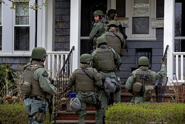 Heavily armed police officers conducted house to house searches in the neighborhoods of Watertown, Mass., on April 19 in a massive manhunt for a suspe