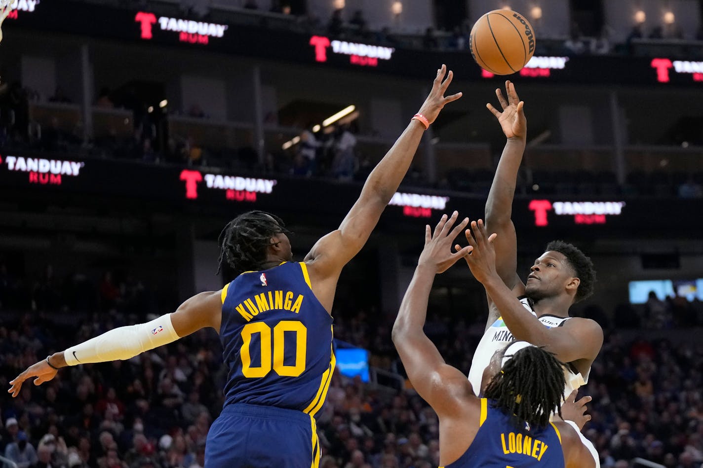 Minnesota Timberwolves guard Anthony Edwards, top right, shoots against Golden State Warriors forward Jonathan Kuminga (00) and forward Kevon Looney during the first half of an NBA basketball game in San Francisco, Sunday, Feb. 26, 2023. (AP Photo/Jeff Chiu)