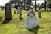 Dressed in period costume, Allison Drtina of the Scott County Historical Society leads a tour of Civil War gravestones at Oakwood Cemetery in Belle Pl