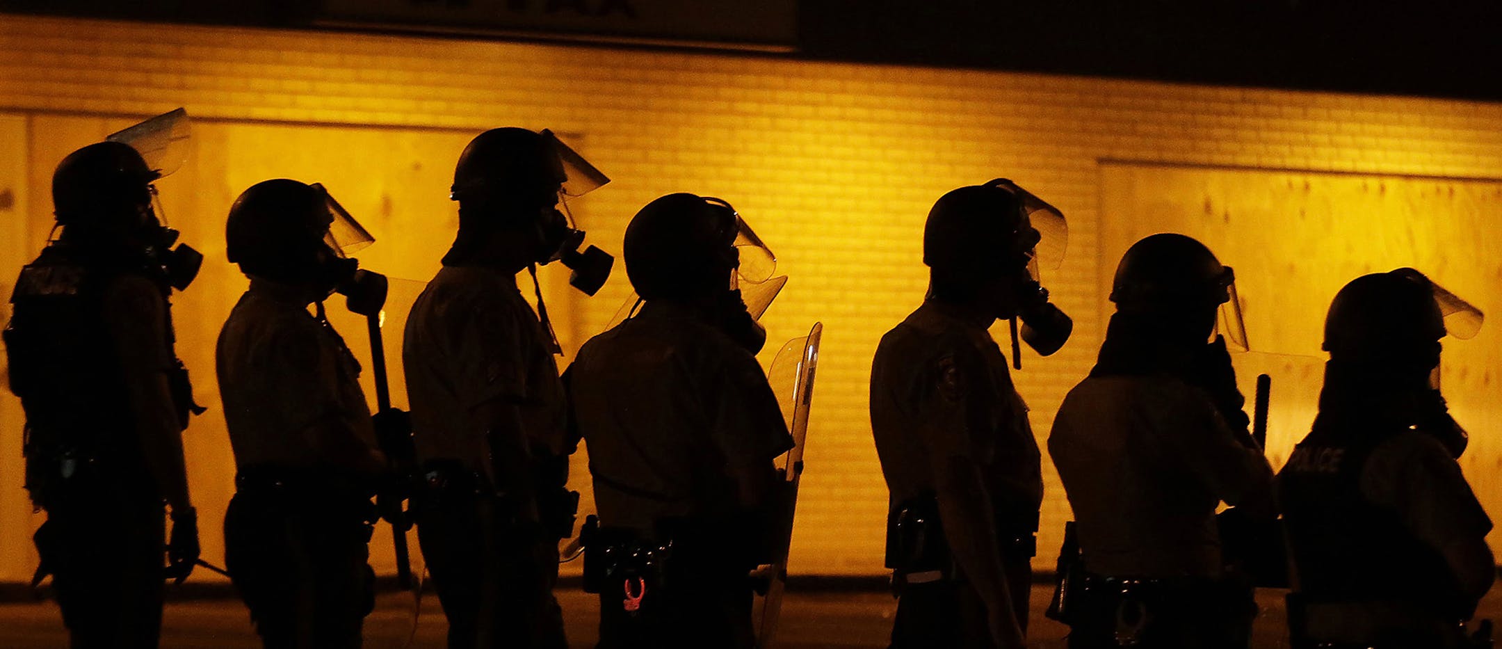 FILE - In this Aug. 17, 2014 file photo, police wait to advance after tear gas was used to disperse a crowd during a protest for Michael Brown, who was killed by a police officer Aug. 9 in Ferguson, Mo. The Ferguson City Council, set to meet Tuesday, Sept. 9, 2014, for the first time since the fatal shooting of Brown, said it plans to establish a review board to help guide the police department and make other changes aimed at improving community relations. (AP Photo/Charlie Riedel, File) ORG XMI