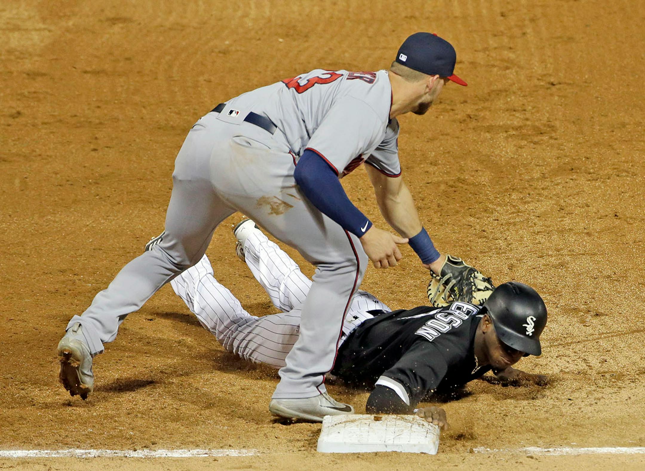 Chicago White Sox's Tim Anderson dives safely back to first base against Minnesota Twins first baseman Mitch Garver during the fourth inning of a baseball game Thursday, Aug. 24, 2017, in Chicago.