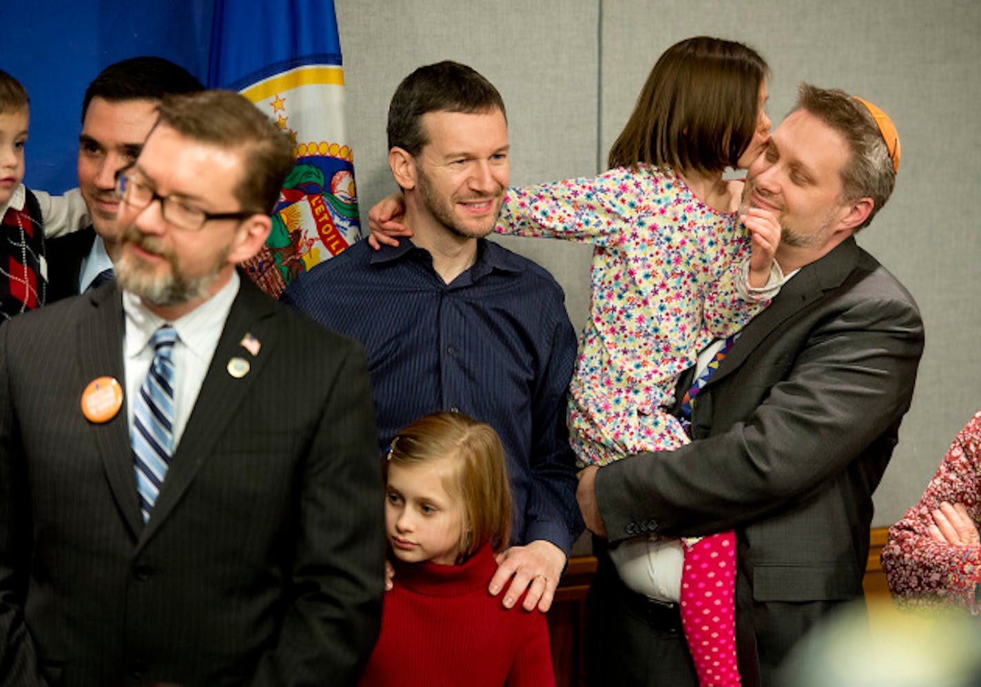 Rabbi Michael Latz got a kiss from his daughter after speaking at the press conference.  He was there with husband Michael Simon, center.  Surrounded by same-sex couples and their children, Senator Scott Dibble and Rep. Karen Clark introduced their bill to legalize same-sex marriages in Minnesota. Wednesday, February 27, 2013.    ]   GLEN STUBBE * gstubbe@startribune.com  EDS:  He Asked that childrens names or ages not be used.