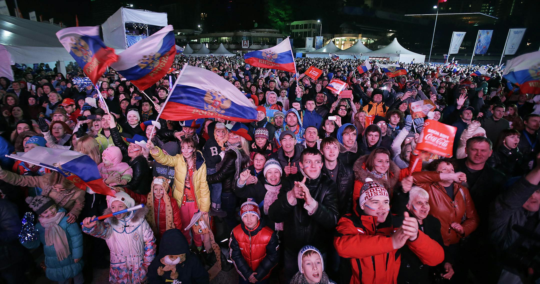 Supporters wave the Russian national flag and scream "Russia" as the Russian team make their appearance during the live telecast of the 2014 Winter Olympics opening ceremony, Friday, Feb. 7, 2014, in downtown Sochi, Russia. (AP Photo/Wong Maye-E)