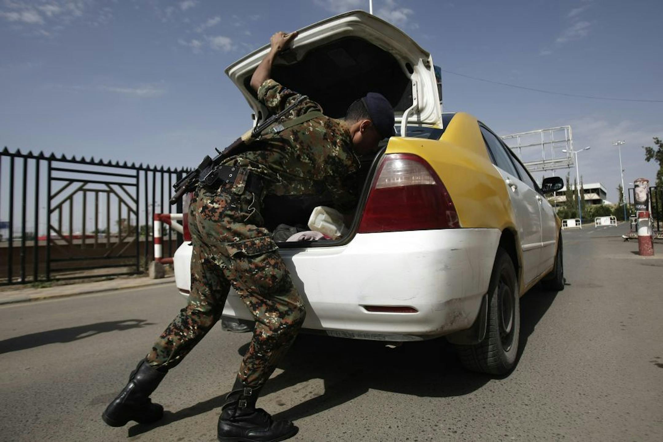 A policeman checks a car at the entrance of Sanaa International Airport, in Yemen, Wednesday, Aug. 7, 2013.