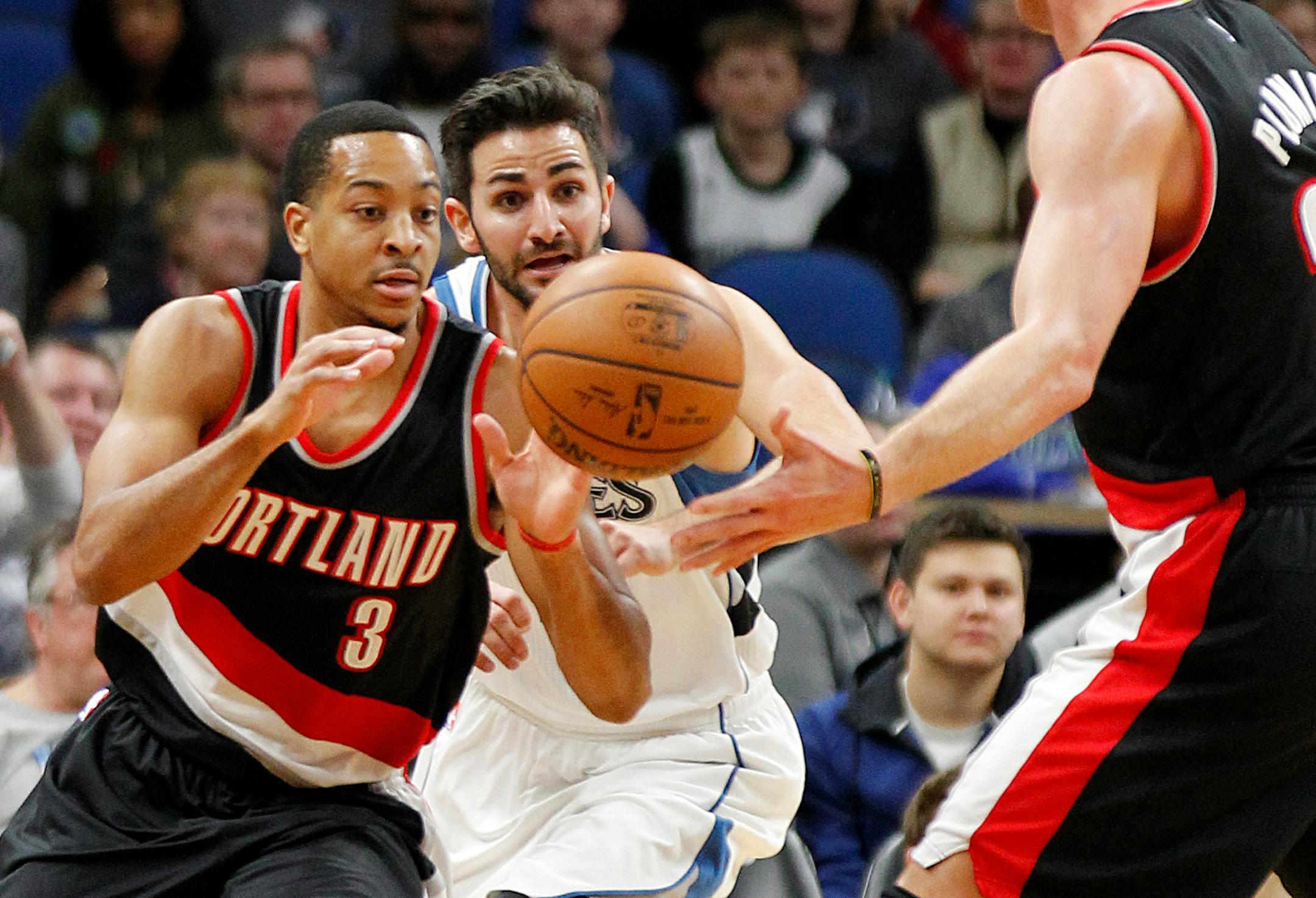 Portland Trail Blazers guard C.J. McCollum (3) receives a pass from forward Mason Plumlee 24) with Minnesota Timberwolves guard Ricky Rubio (9) pursuing during the first quarter of an NBA basketball game in Minneapolis, Sunday, Jan. 1, 2017. (AP Photo/Andy Clayton-King)