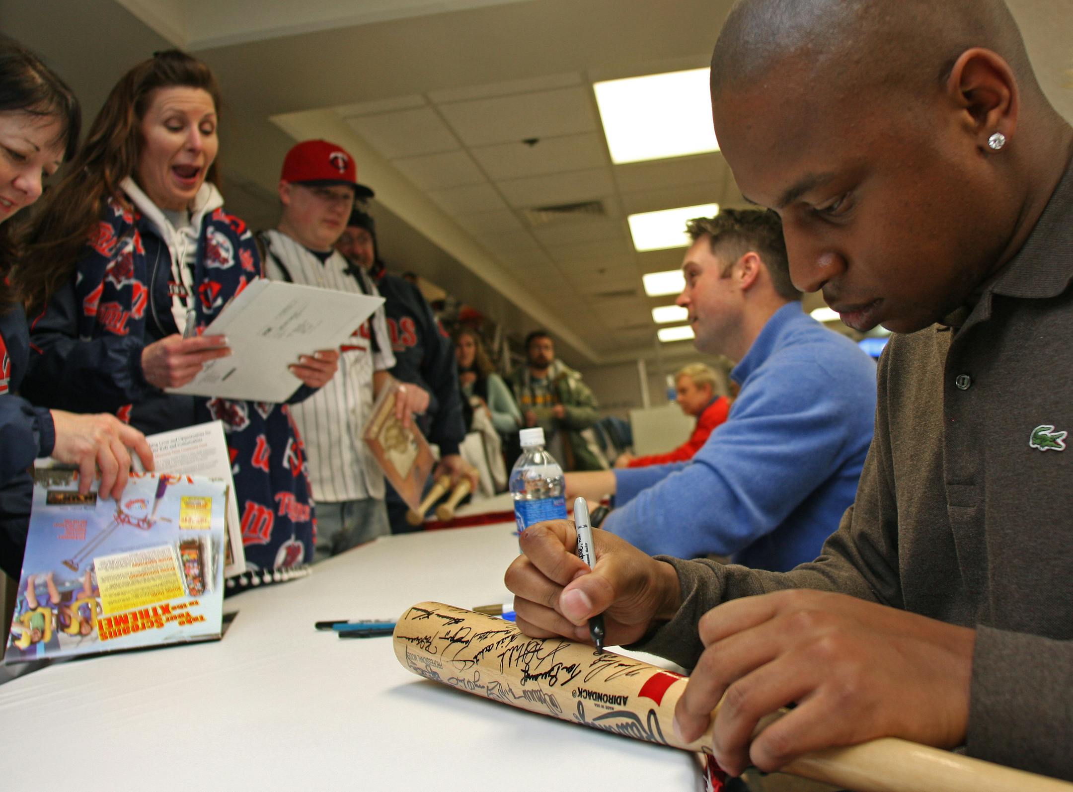 Twins Michael Cuddyer and Delmon Young signed everything from balls, to bats to bases during their autograph session at Twinsfest.