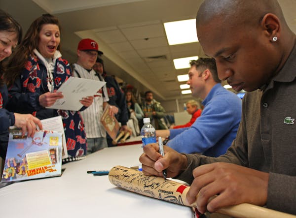 Twins Michael Cuddyer and Delmon Young signed everything from balls, to bats to bases during their autograph session at Twinsfest.