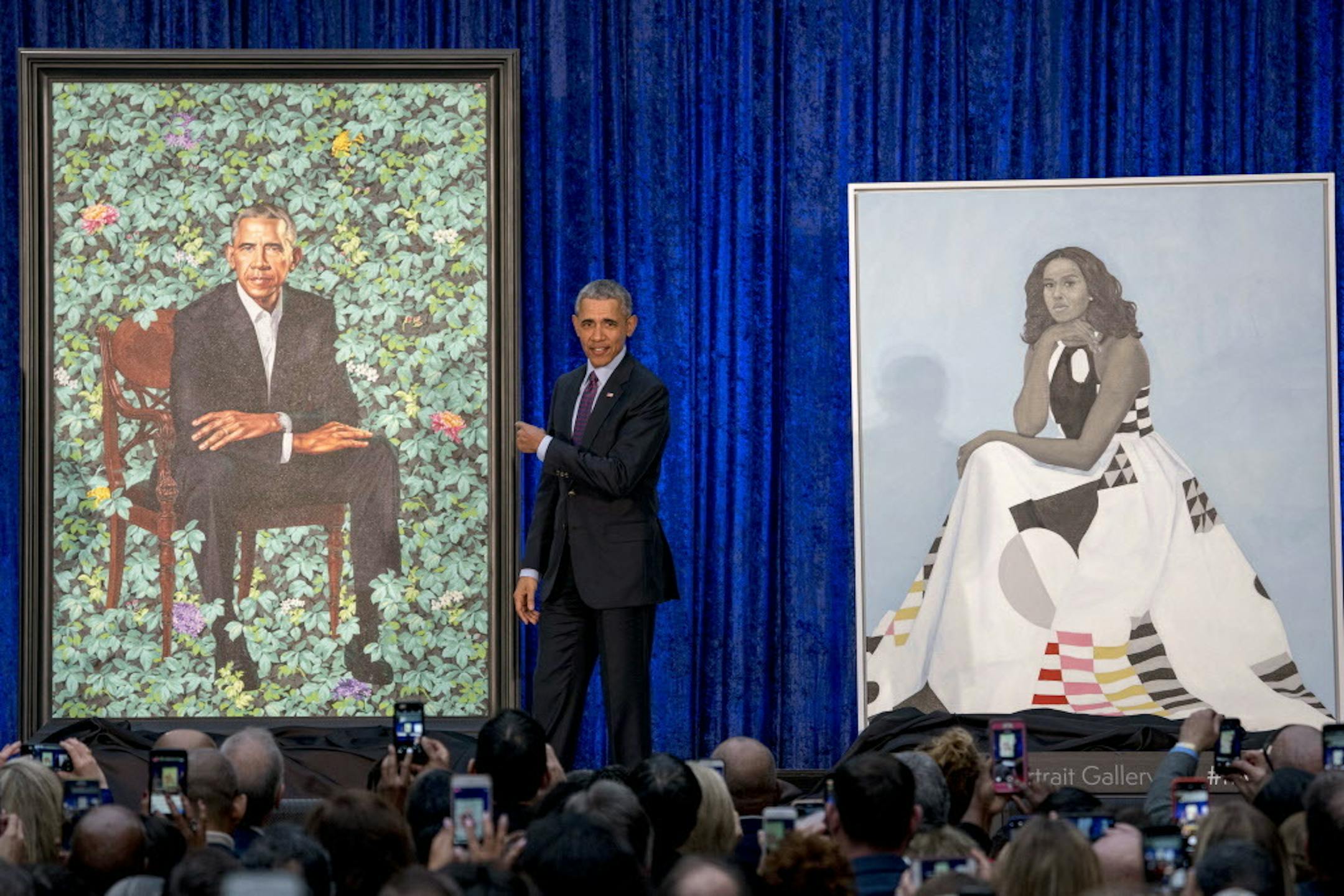 Former President Barack Obama, center, stands on stage during the unveiling of the Obama's official portraits at the Smithsonian's National Portrait Gallery, Monday, Feb. 12, 2018, in Washington. (AP Photo/Andrew Harnik)