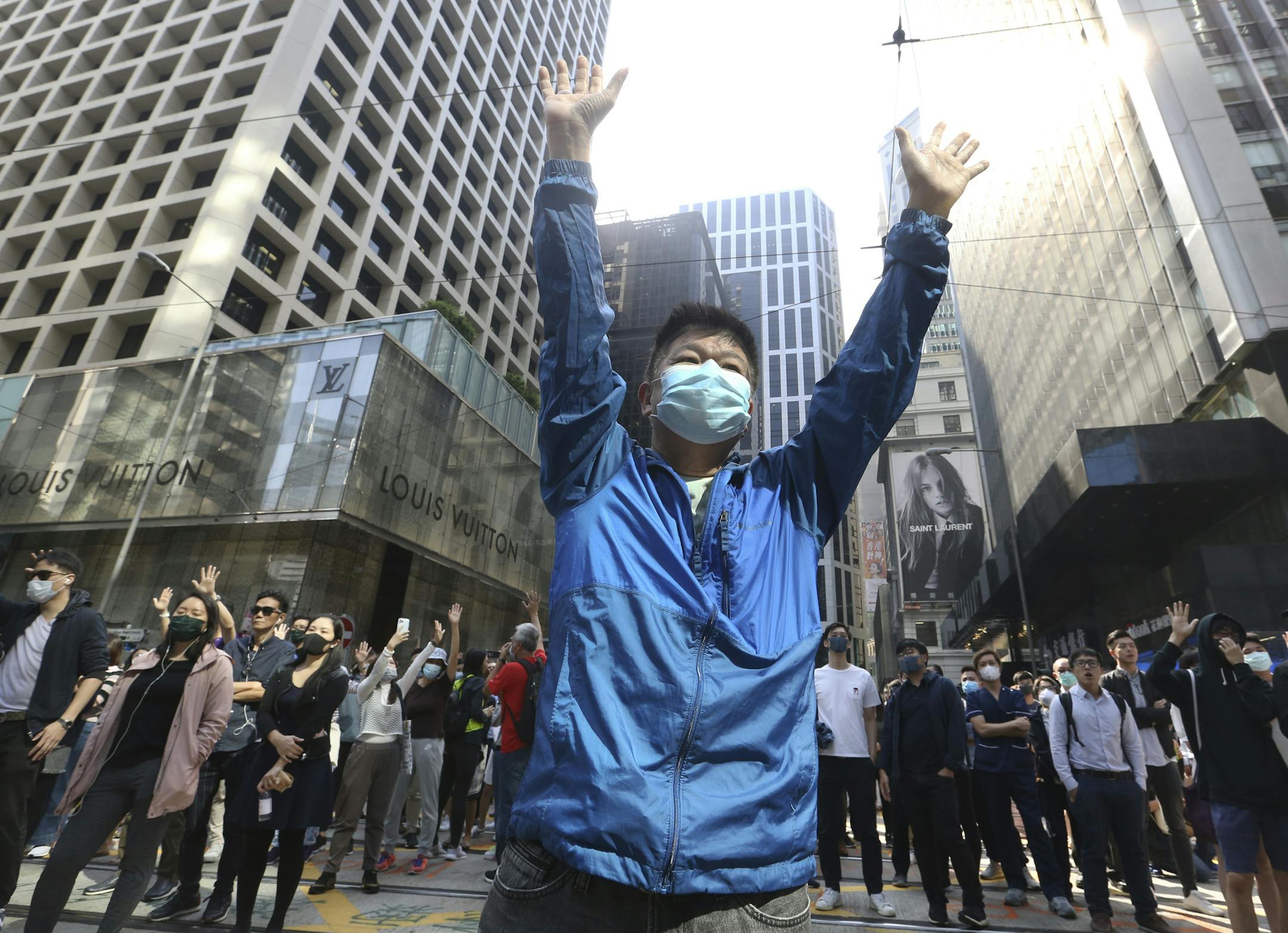 A demonstrator raises his hands during a protest in the financial district in Hong Kong, Friday, Nov. 15, 2019. Protesters who have barricaded themselves in a Hong Kong university partially cleared a road they were blocking and demanded that the government commit to holding local elections on Nov. 24. (AP Photo/Achmad Ibrahim) ORG XMIT: XAI206