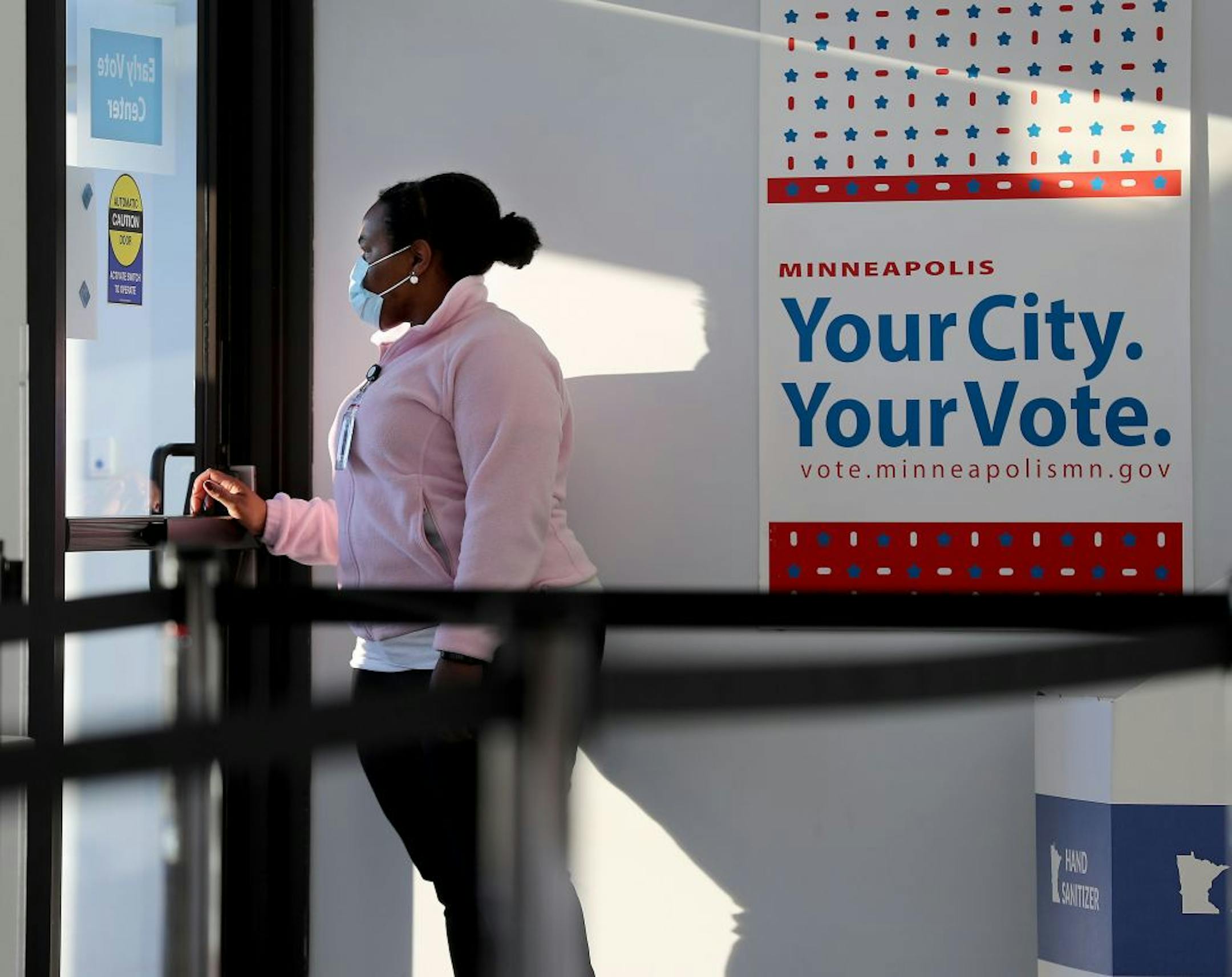 Election worker Simone Frierson looked at at the line of voters as the 8 a.m. opening approached during early voting at Minneapolis Elections and Voter Services Friday in Minneapolis.