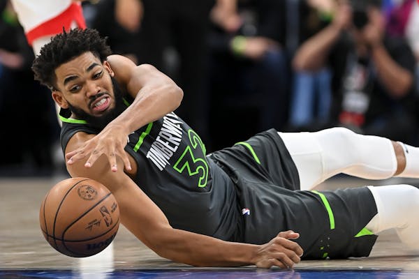 Timberwolves center Karl-Anthony Towns scrambled to the court for a loose ball against the Rockets.