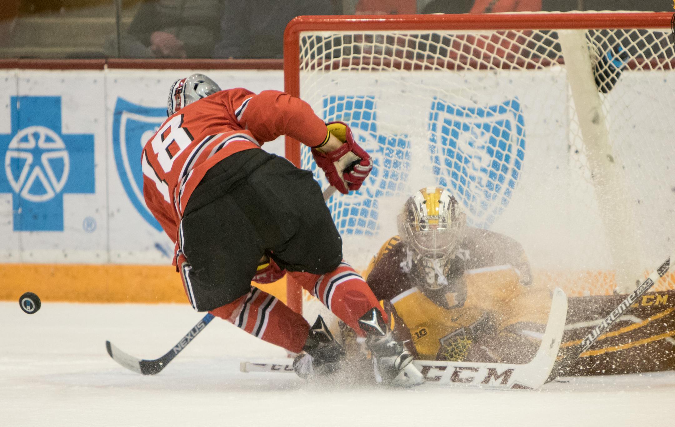 Minnesota Golden Gophers goalie Eric Schierhorn (37) gets a face full of ice but makes the save on Ohio State Buckeyes forward Luke Stork (18) as the Minnesota Golden Gophers hosted the Ohio State Buckeyes in Big Ten Conference action on December 5, 2015. ] Special to Star Tribune MATT BLEWETT � matt@mattebphoto.com - December 5, 2015, Minneapolis, MN, Big Ten Hockey, Minnesota Golden Gophers vs. Ohio State Buckeyes, 753323 UPUK 120615