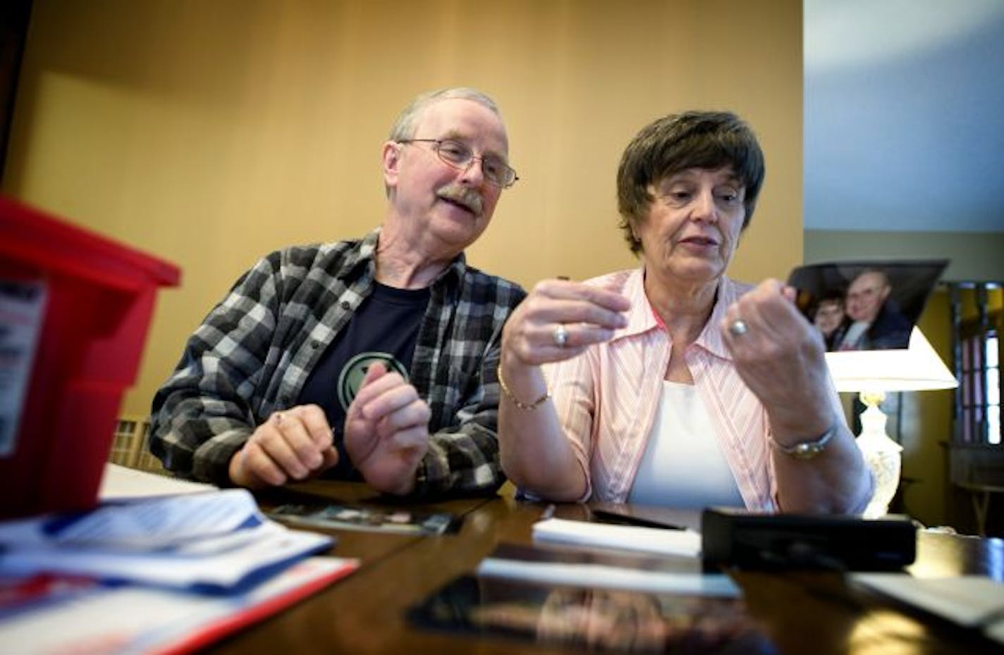 Jim and LaVonne Rasmusson went through old photo prints to decide which to digitize into their computer and which to throw out.