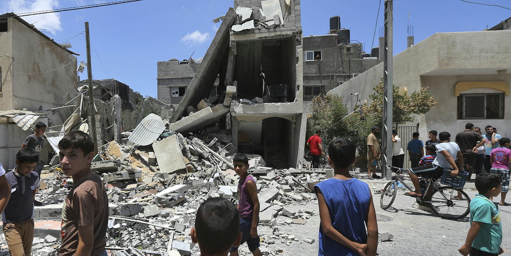 Palestinians look at the damage to a house following an overnight Israeli missile strike in Rafah, southern Gaza Strip, Monday, July 14, 2014. The Israeli military said it downed a drone on Monday along the country's southern coastline, the first time it encountered an unmanned aircraft since the campaign against Gaza Strip militants began last week. (AP Photo/Lefteris Pitarakis) ORG XMIT: MIN2014071412320193