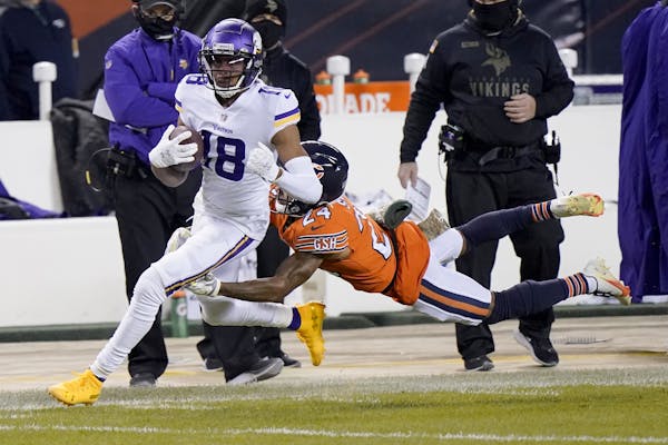 Minnesota Vikings wide receiver Justin Jefferson (18) runs with the ball as Chicago Bears cornerback Buster Skrine (24) defends during the first half 