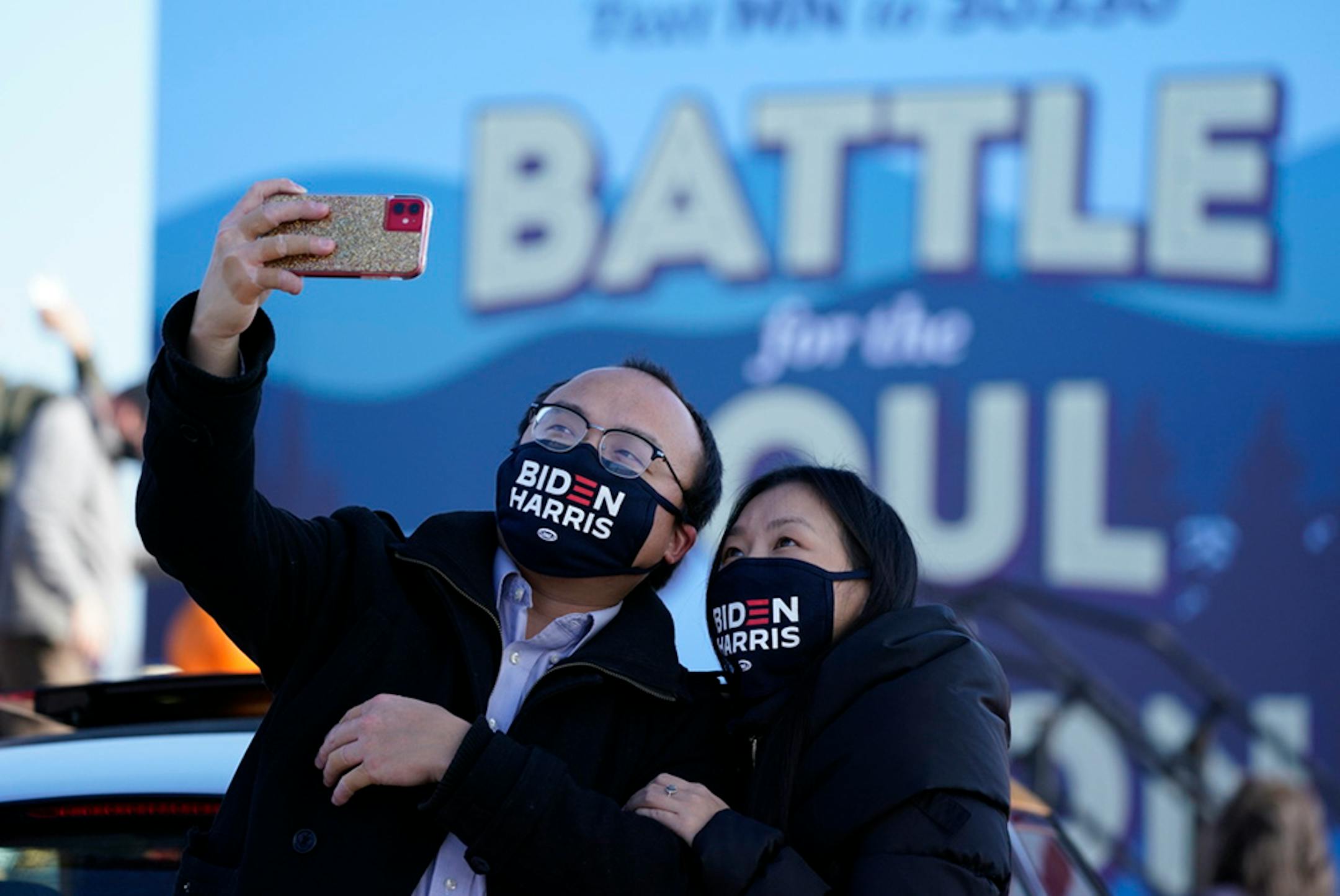 Souvan Lee, left, and girlfriend Hnuchee Vang, both of Richfield, took selfies before former Vice President Joe Biden spoke during a drive-in campaign event in Falcon Heights.