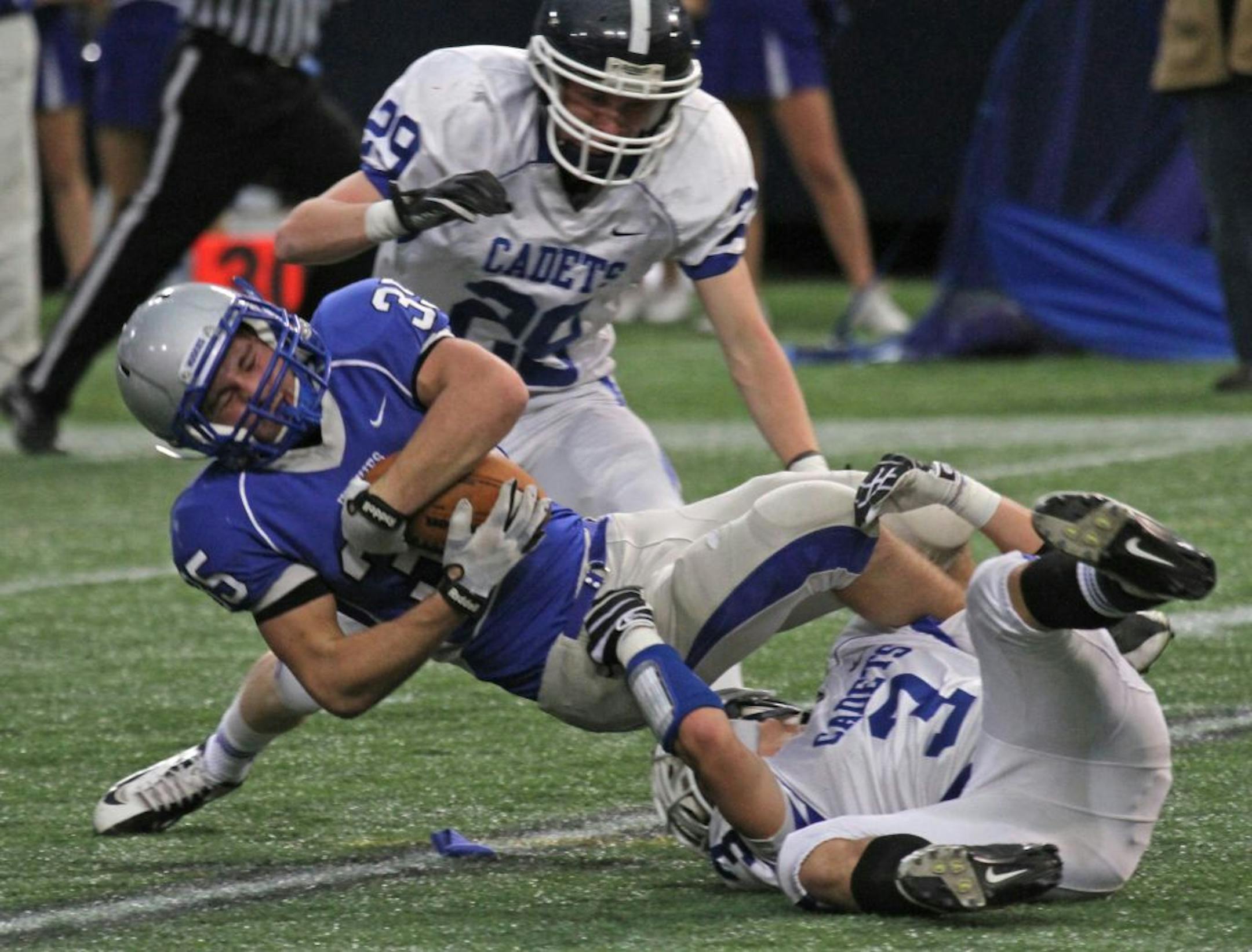Owatonna's Caleb Satterlund was tripped up by St. Thomas Academy Nick Waldvogel on a kick-off return.