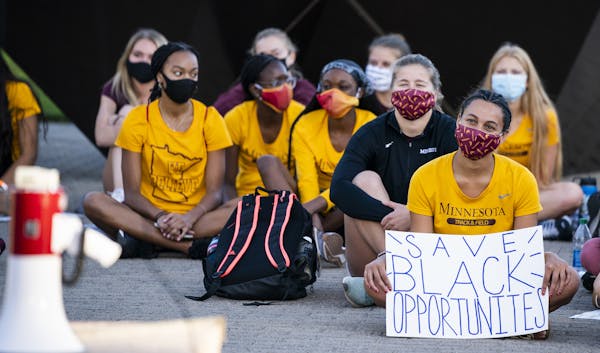 U student athletes staged a sit-in to protest sports programs being cut outside the McNamara Alumni Center on the University of Minnesota campus. ] LE