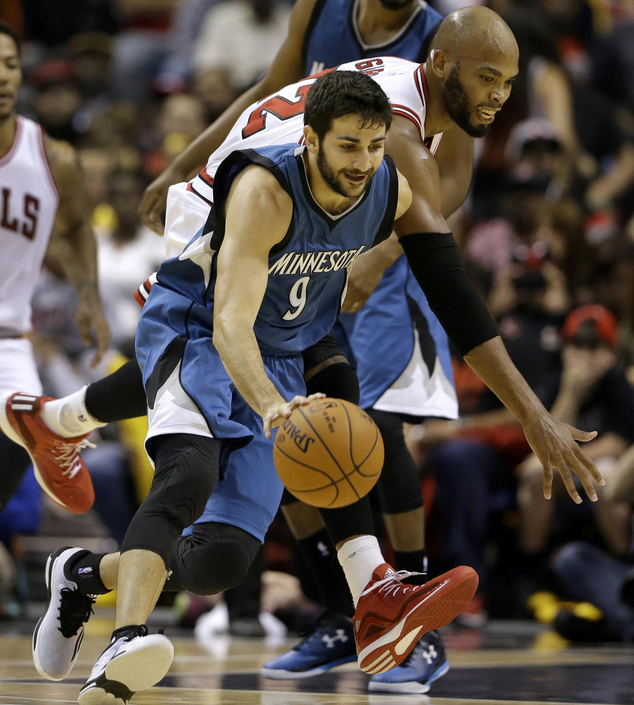 Minnesota Timberwolves' Ricky Rubio, front, and Chicago Bulls' Taj Gibson reach for a loose ball during the first half of a preseason NBA basketball game Friday, Oct. 24, 2014, in St. Louis. (AP Photo/Jeff Roberson)