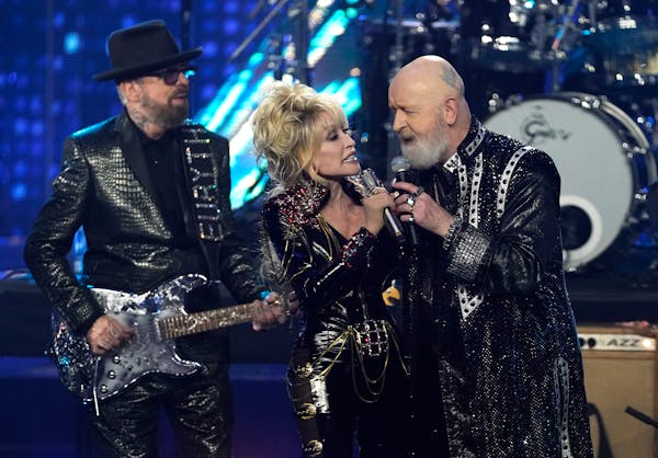 Dave Stewart of Eurythmics, from left, Dolly Parton and Rob Halford of Judas Priest jam on “Jolene” during the Rock & Roll Hall of Fame induction 