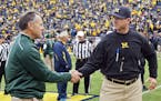 FILE - In this Oct. 17, 2015, file photo, Michigan State head coach Mark Dantonio shakes hands with Michigan head coach Jim Harbaugh on the Michigan S