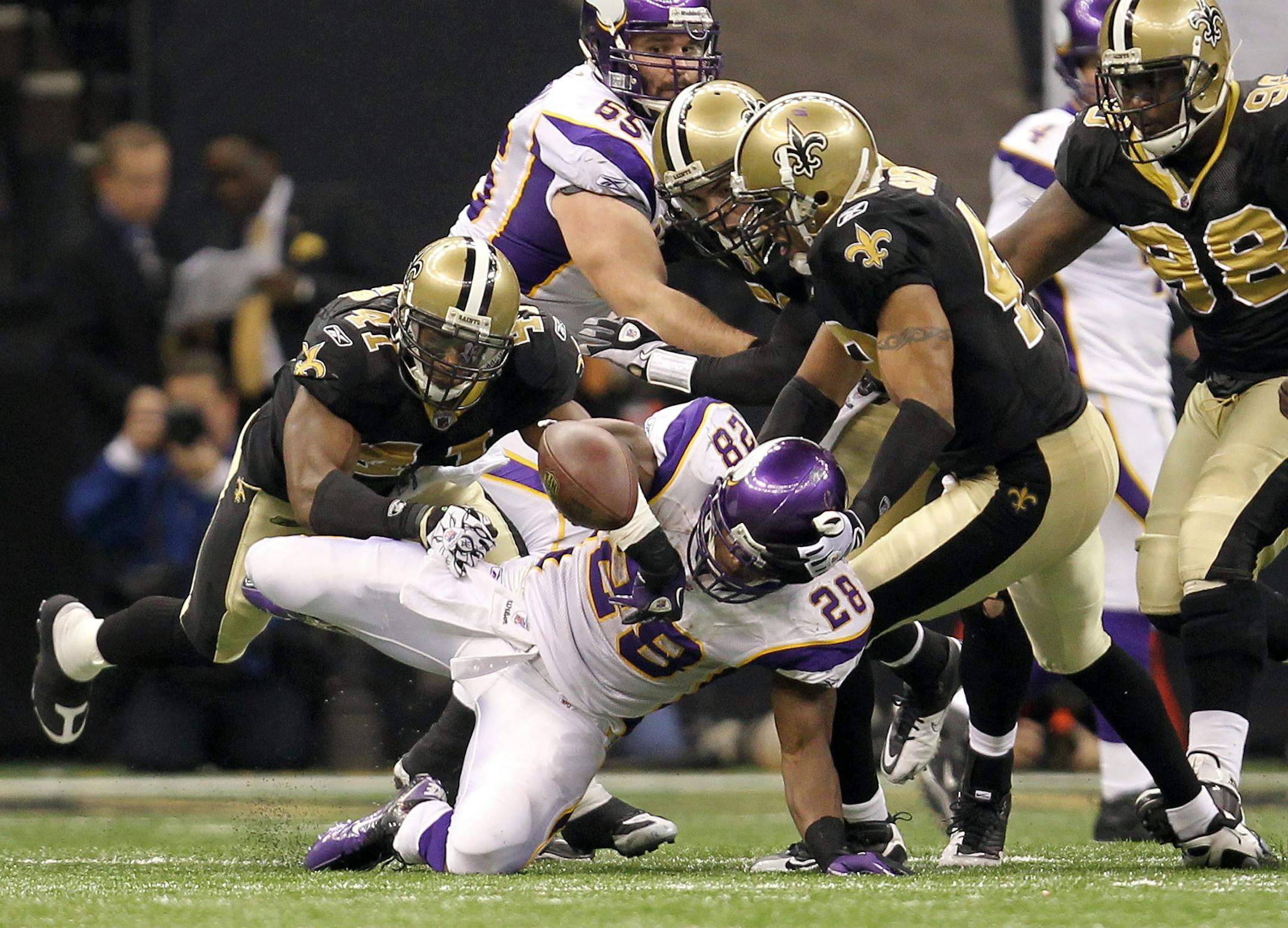 Vikings running back Adrian Peterson (28) fumbled the ball -- one of his two fumbles in the third quarter against the Saints -- but recovered it. New Orleans beat the Vikings 31-28 in overtime in the NFC Championship Game.