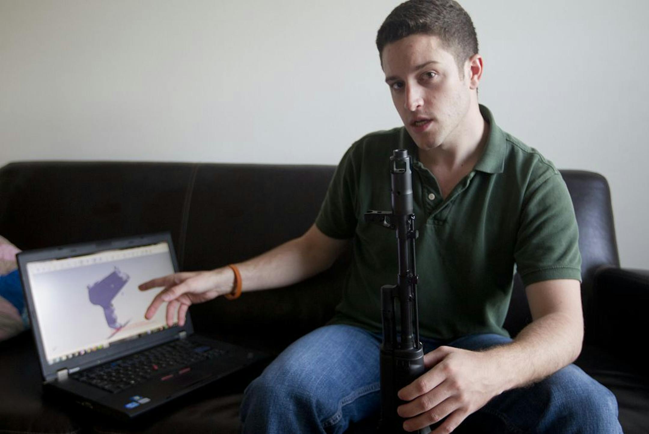 "Wiki Weapons" project leader Cody Wilson points to his laptop screen displaying an image of a prototype plastic gun on the screen.