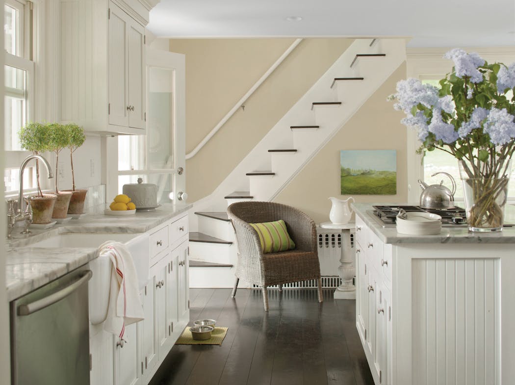 Benjamin Moore White Dove Advance semigloss paint was used on cabinets for an update on a traditional-style kitchen. But before you paint your cabinets, step back and consider the domino effect this may create. 