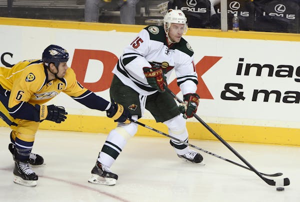 Minnesota Wild right wing Dany Heatley (15) passes the puck as he is defended by Nashville Predators defenseman Shea Weber (6) in the third period of 