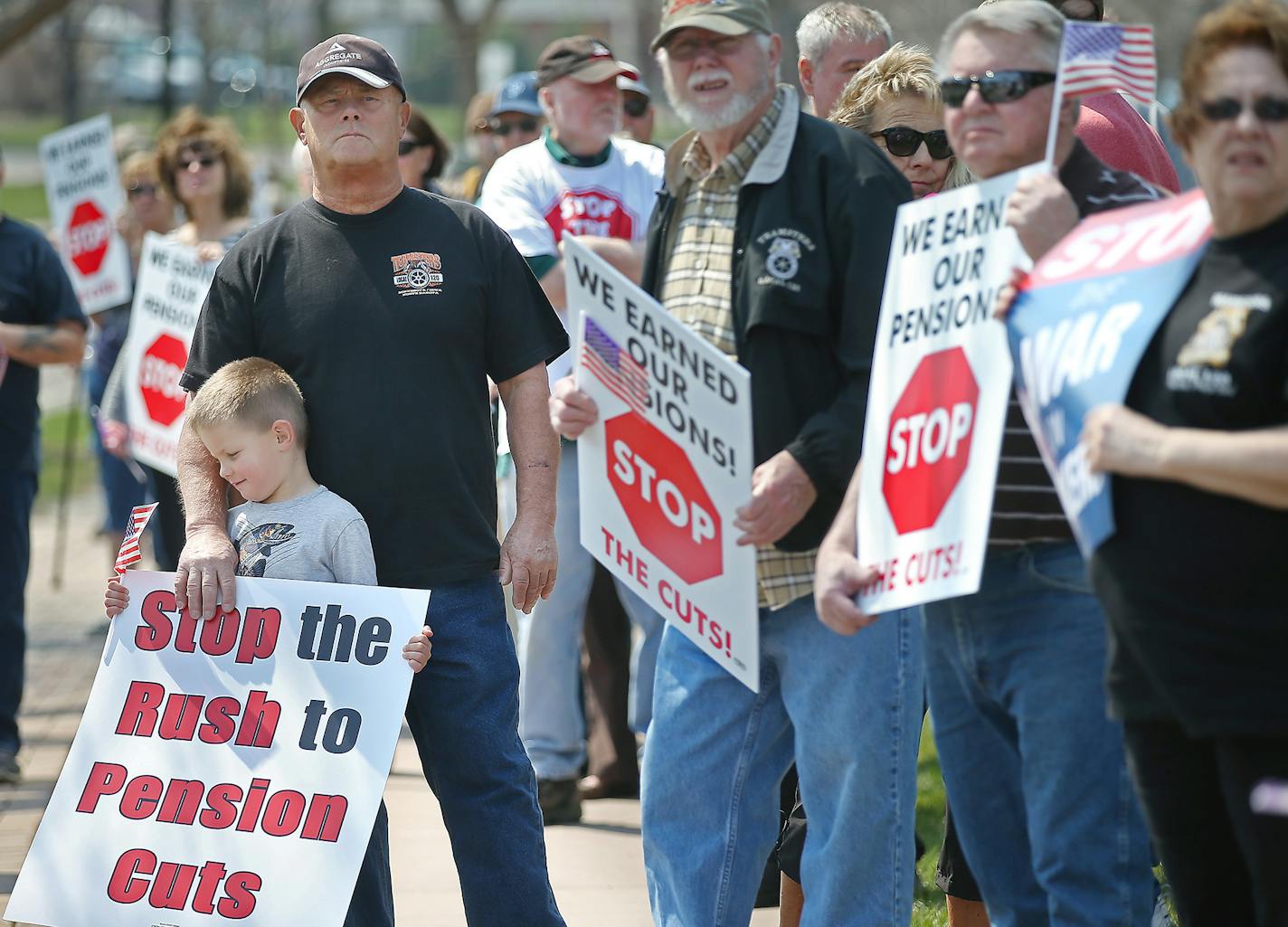 Perry Martin, who worked more than 30 years for a cement company, held onto his grandson Austin Martin, 5, as they joined other Teamsters for a rally outside the offices of U.S. Rep. John Kline, Thursday, April 14, 2016 in Burnsville, MN. Teamsters are facing pension cuts of 50 percent or more. Kline was one of two Congressmen who authored an amendment to a 2014 appropriations bill that made it possible for the pensions to be slashed.