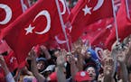 Pro-government wave Turkish flags as they protest against the attempted coup, in Istanbul, Tuesday, July 19, 2016. The Turkish government accelerated 