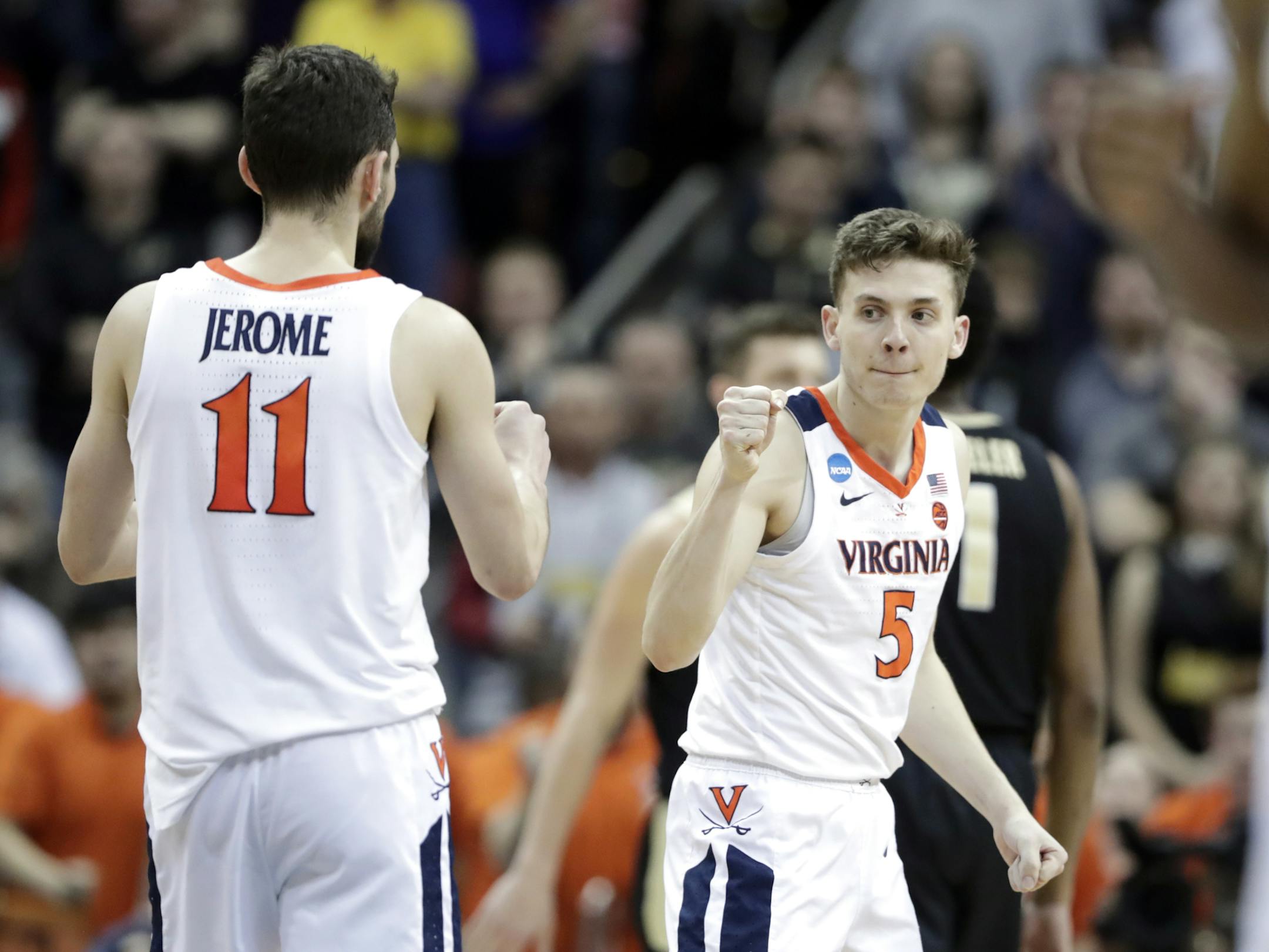 Virginia's Ty Jerome (11) and Kyle Guy celebrate during overtime of the men's NCAA Tournament college basketball South Regional final game against Purdue, Saturday, March 30, 2019, in Louisville, Ky. Virginia won 80-75. (AP Photo/Michael Conroy)