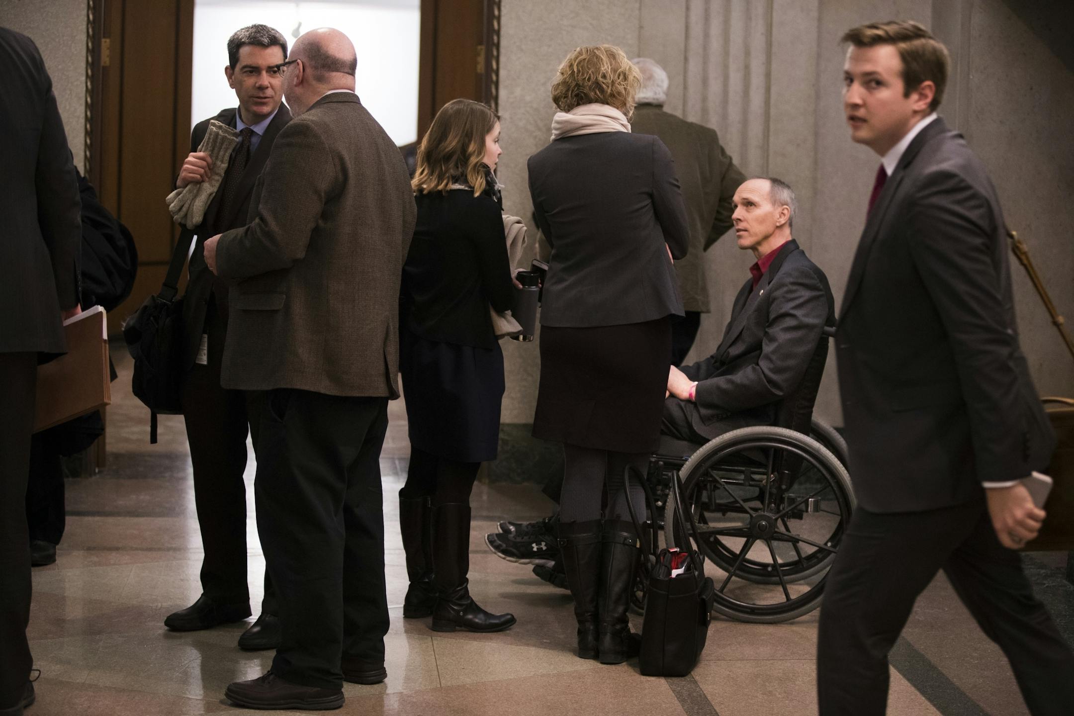 Rep. Rod Hamilton talks with people in the hallway outside the hearing room after a Ways and Means Committee hearing.