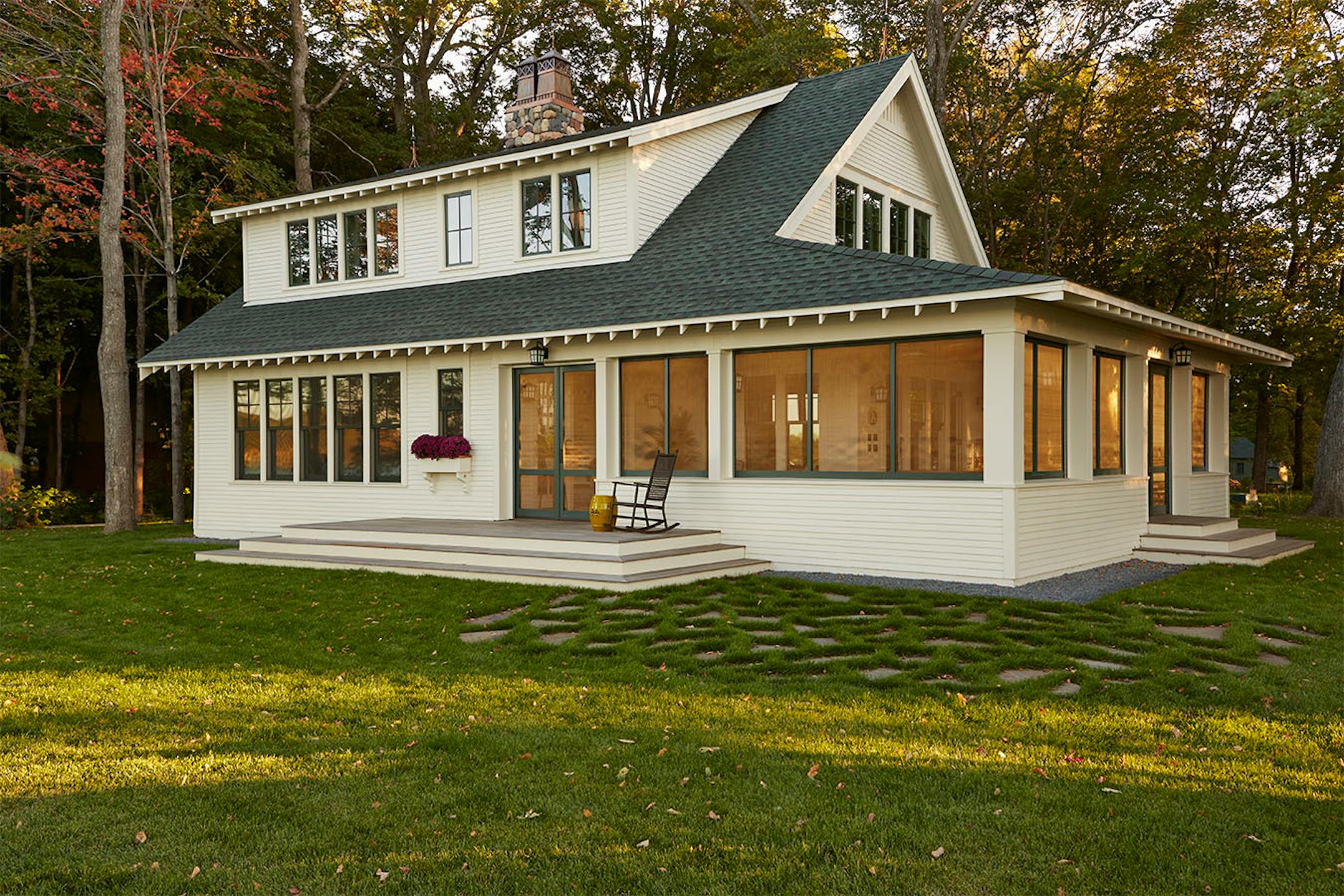 The Crane Island cottage exterior combines contemporary low-maintenance fiber-cement siding with traditional shed dormers, wrap-around screen porch and double-hung windows.