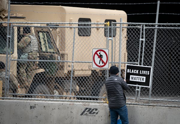 Michael Chauss put up a Black Lives Matter sign on a fence outside the Hennepin County Government Center as the jury selection for the trial of Derek 