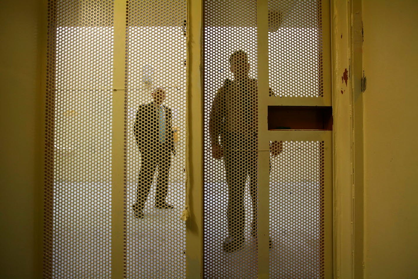 FILE -- A view of prison employees from inside a cell in the Secured Housing Unit, where prisoners are held in isolation in windowless cells, at Pelican Bay State Prison in Crescent City, Calif.