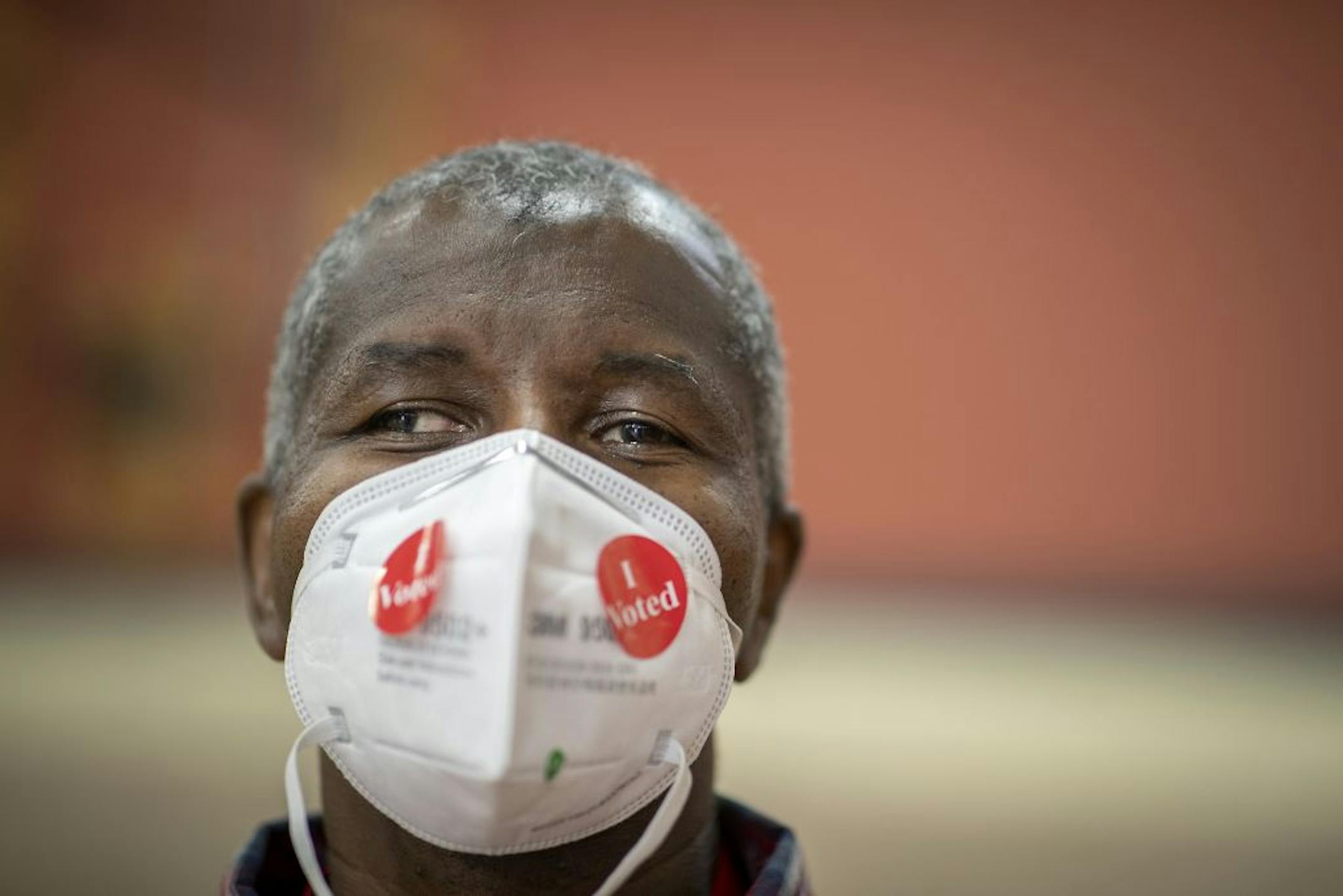 Election volunteer Dwane Martin, cq, who has volunteered for more than five years sported some "I Voted" stickers on his face mask as he handed them out at the Jimmy Lee Recreation Center polling location, Tuesday, August 11, 2020 in St. Paul, MN.
