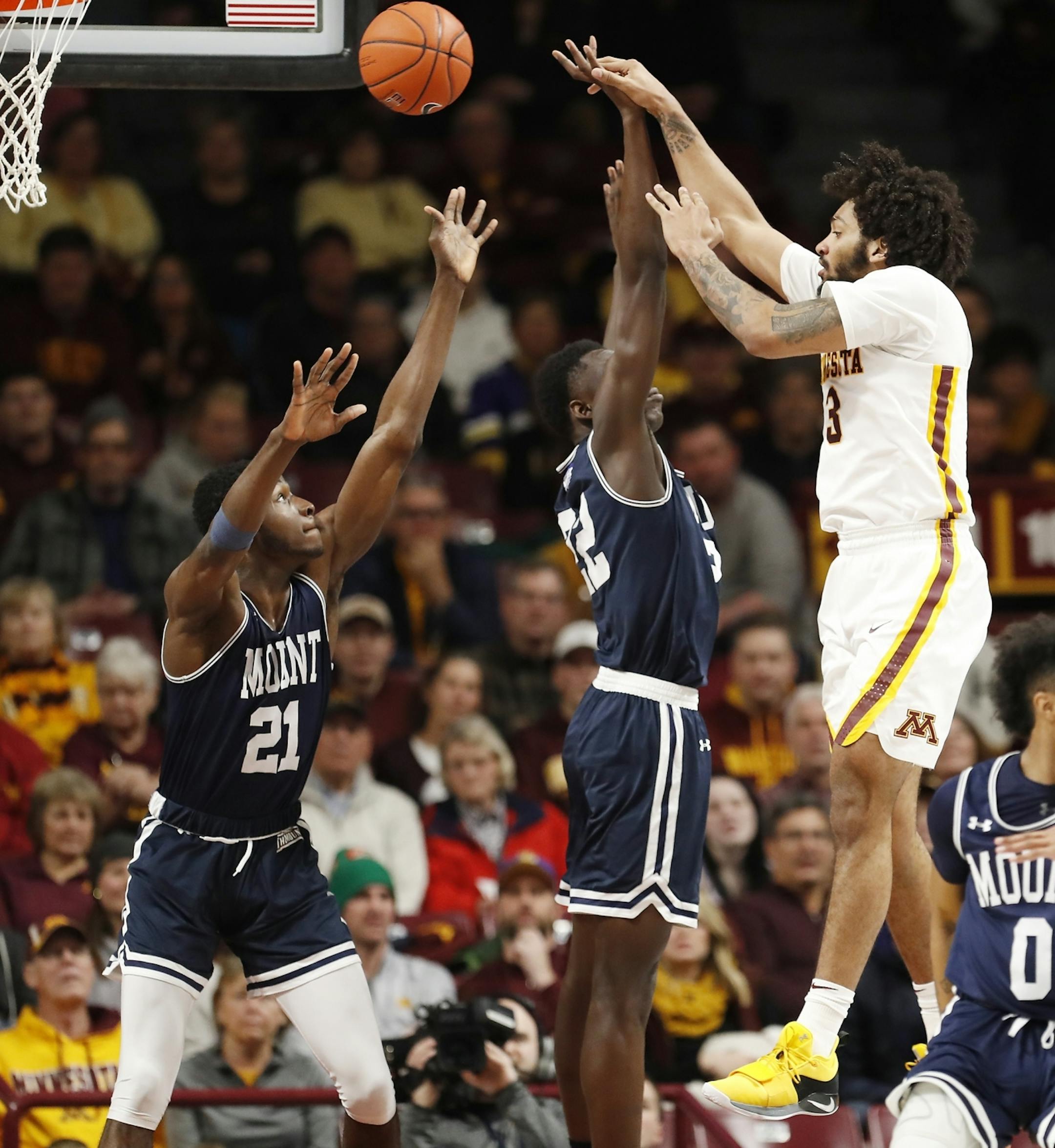 Minnesota forward Jordan Murphy (3) shoots as Mount St. Mary's forward Nana Opoku (22), center, and Mount St. Mary's forward Collin Nnamene (21), left, defend during the second half.